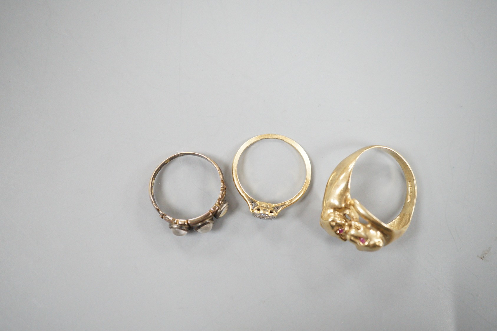 A modern 9ct gold and gem set twin leopards head ring, size S, gross 5.6 grams, a late Victorian 15ct gold and three stone moonstone ring, size M/N (shank cut), gross 3.3 grams and an 18ct and diamond cluster ring, size
